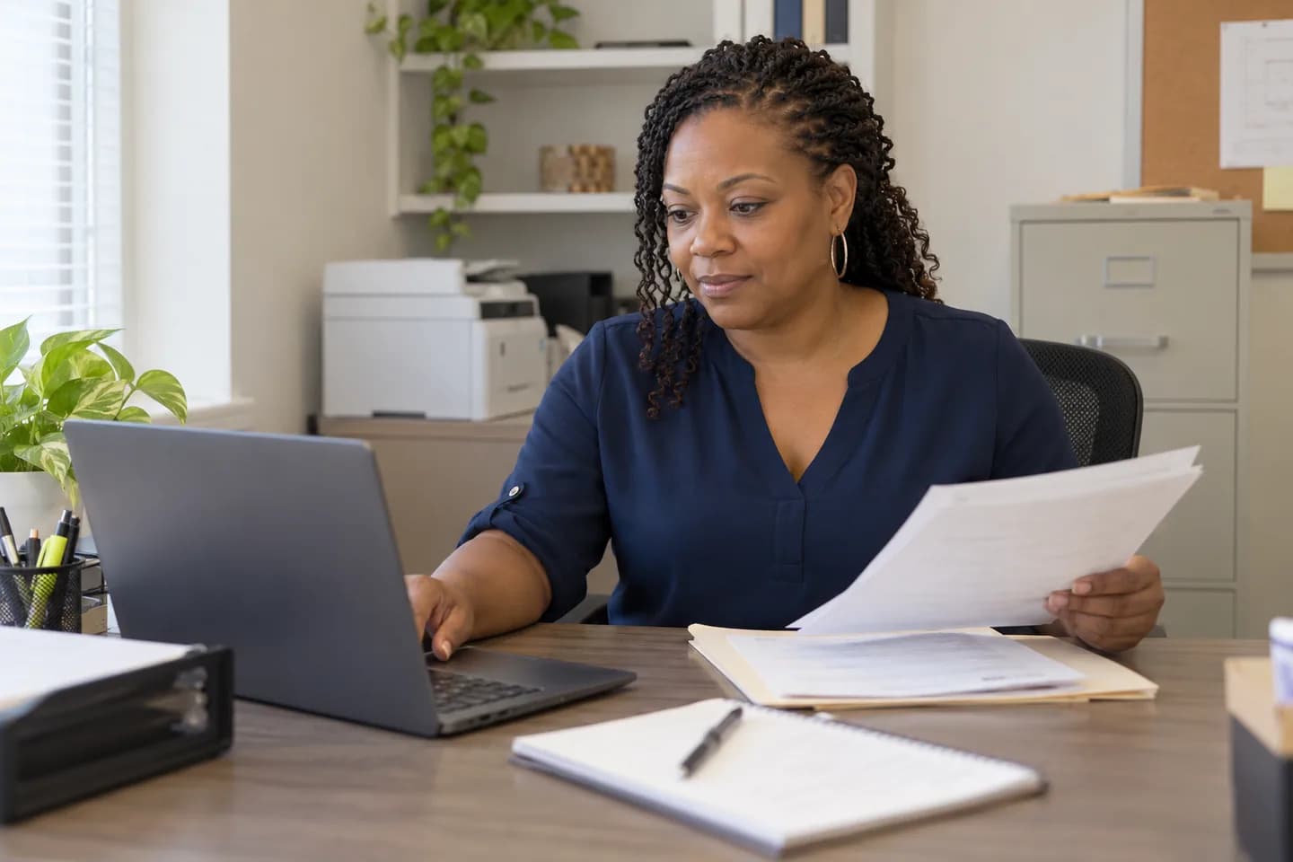Property manager reviewing work orders on a laptop in an on-site leasing office
